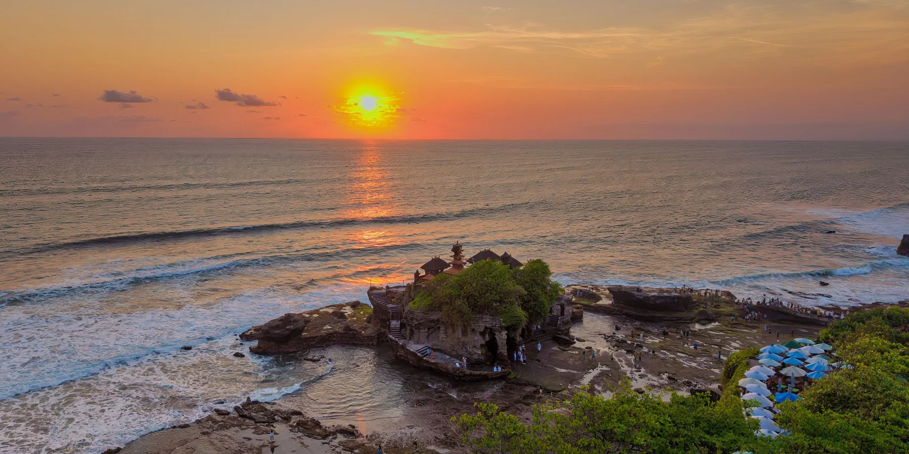 Templo de Tanah Lot sobre el océano durante un atardecer dramático en Bali