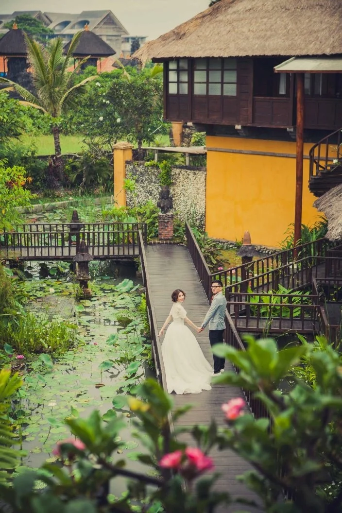 Pareja de recién casados caminando junto al estanque de loto de Hotel Tugu Bali